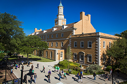 Photo of Hurley Administration building and McConnell tower during spring with people walking