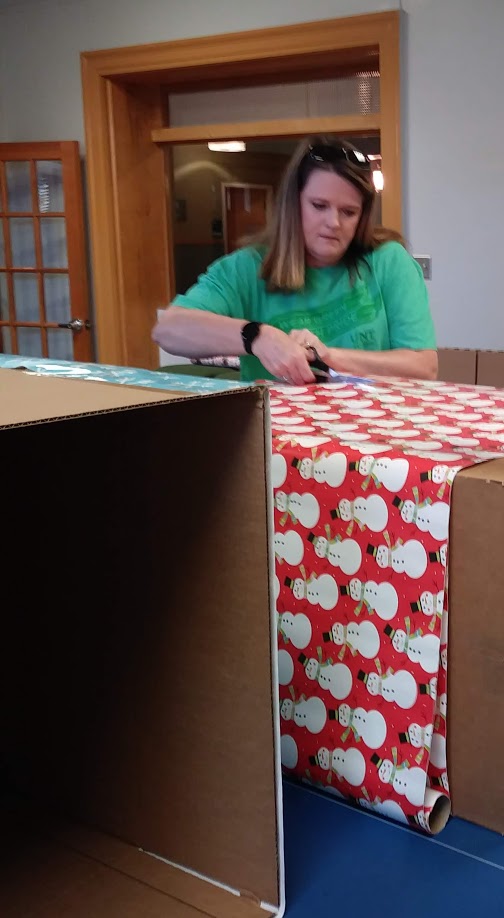 Picture of Staff Senator cutting wrapping paper
